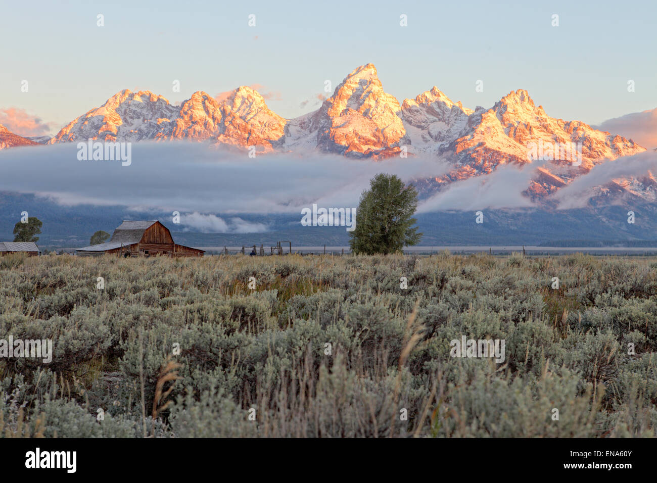 A sunrise view of the Teton mountain range, with the famous Moulton barn in the foreground. Stock Photo