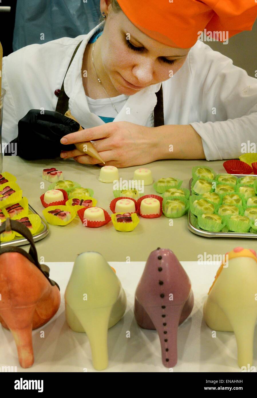 Oldisleben, Germany. 10th Apr, 2015. Master confectionist, Juliane Siedler, words on pralines and edible high heels in the display area of Karin Finger's Goethe Chocolate Factory in Oldisleben, Germany, 10 April 2015. The colorful high-heeled shoes are part of the extensive, high-quality praline production at her company, which was founded ten years ago. Photo: WALTRAUD GRUBITZSCH/dpa/Alamy Live News Stock Photo