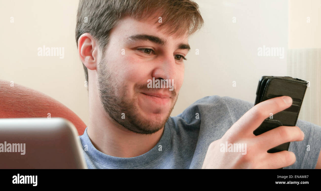 Young man using a phone and laptop. Stock Photo