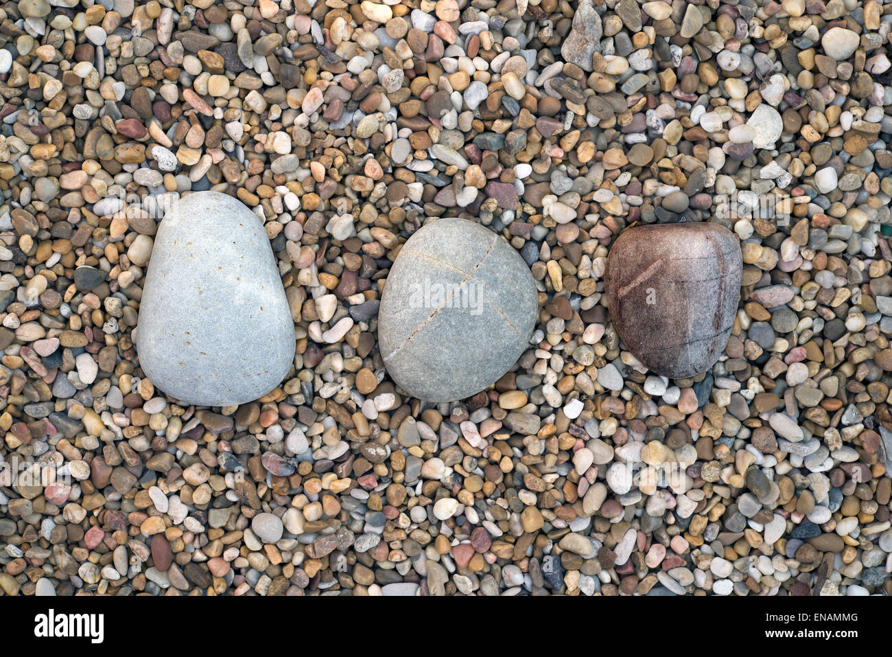 three stones on a gravel floor Stock Photo