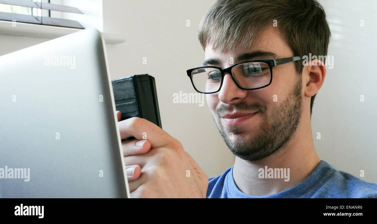 Young man using a phone and laptop. Stock Photo
