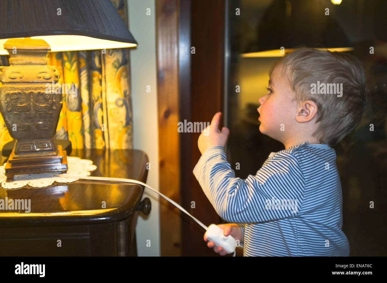 dh child electricity CHILDERN UK Two year old boy baby child switch lamp experiment light at home children experimenting with electricity Stock Photo