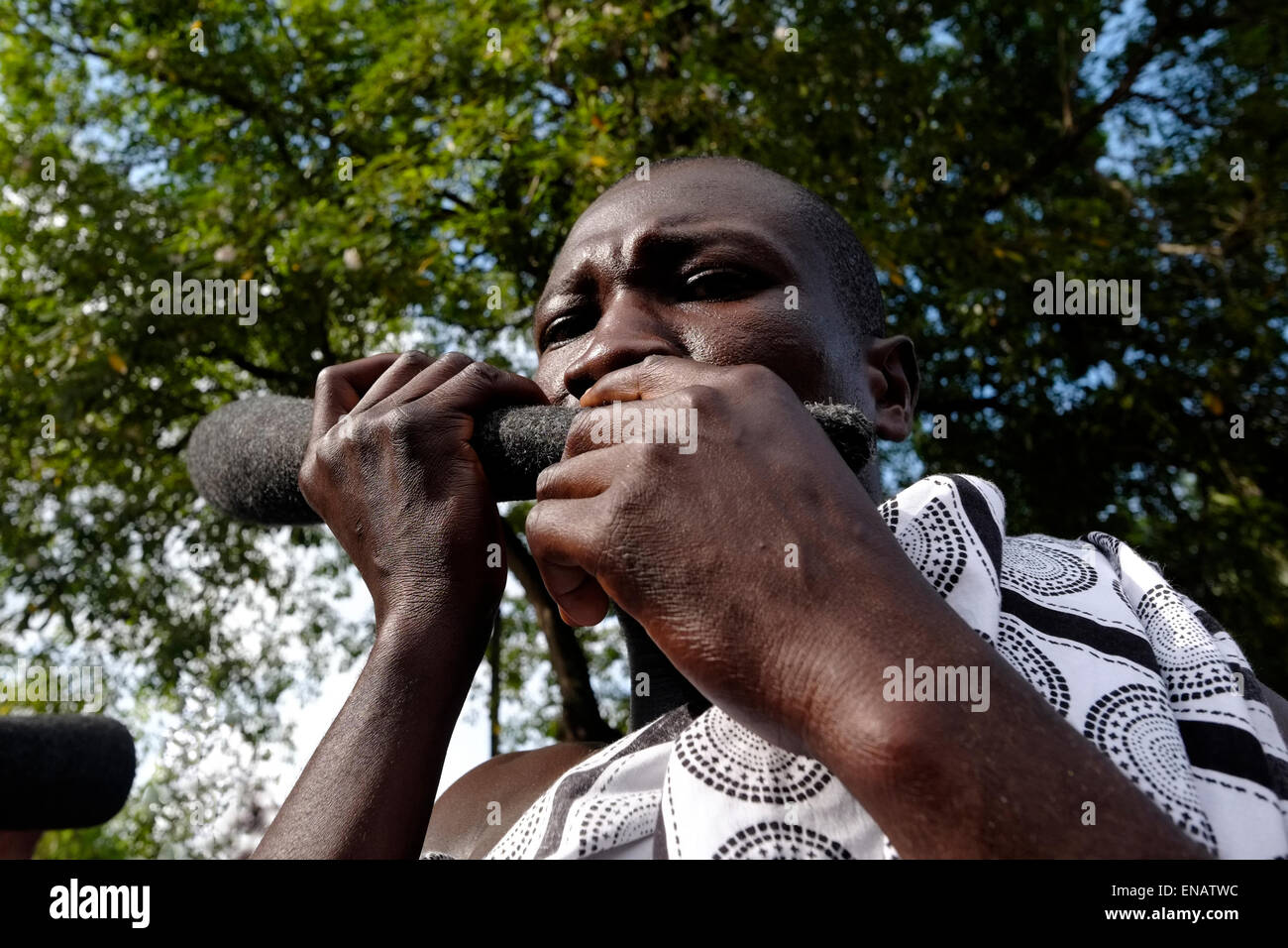 A local man playing a traditional wooden flute in Ghana Africa Stock Photo