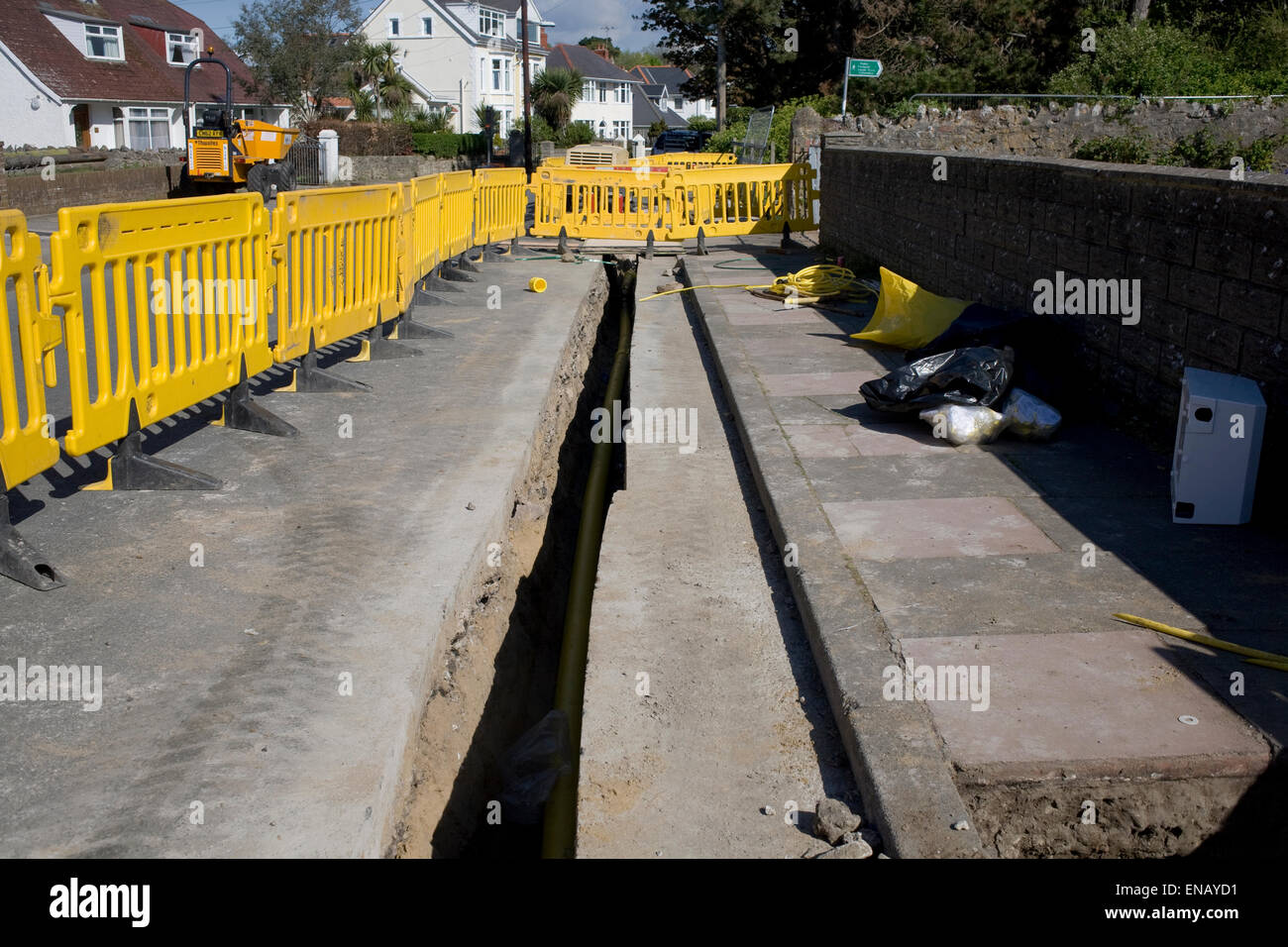 Trench ready for replacement gas main with safety barriers alongside Stock Photo