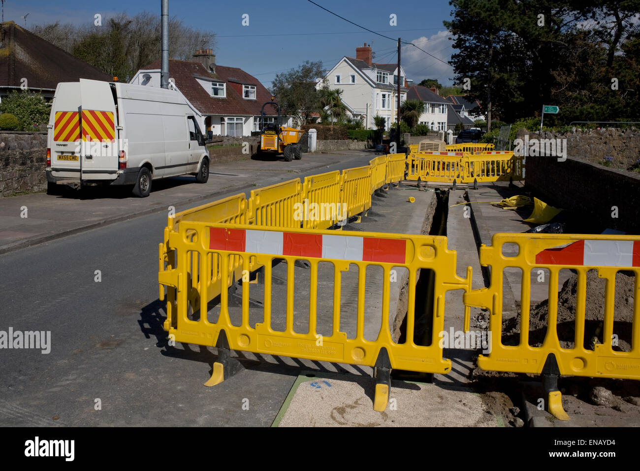 white van, trench and yellow safety barrier during gas main replacement works Stock Photo