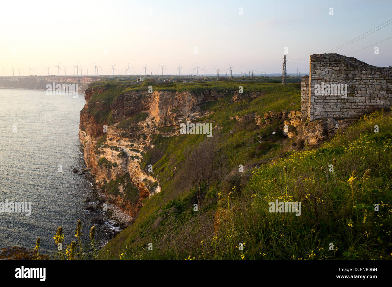 Ancient fortress wall and cliffs on the west side of Cape Kaliakra with wind mills in the background. Stock Photo