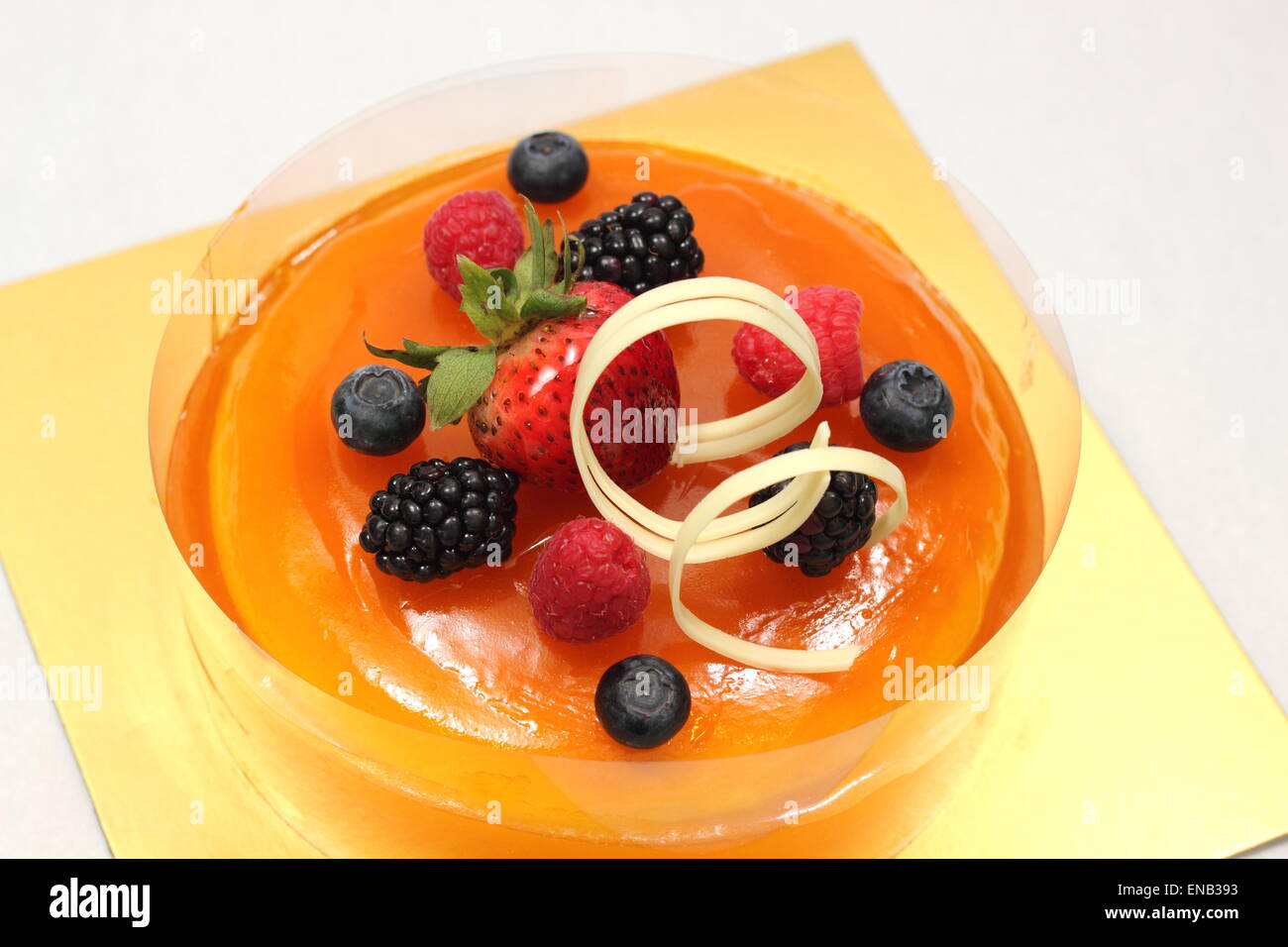 Orange jelly cake and mixed berry garnished Stock Photo Alamy