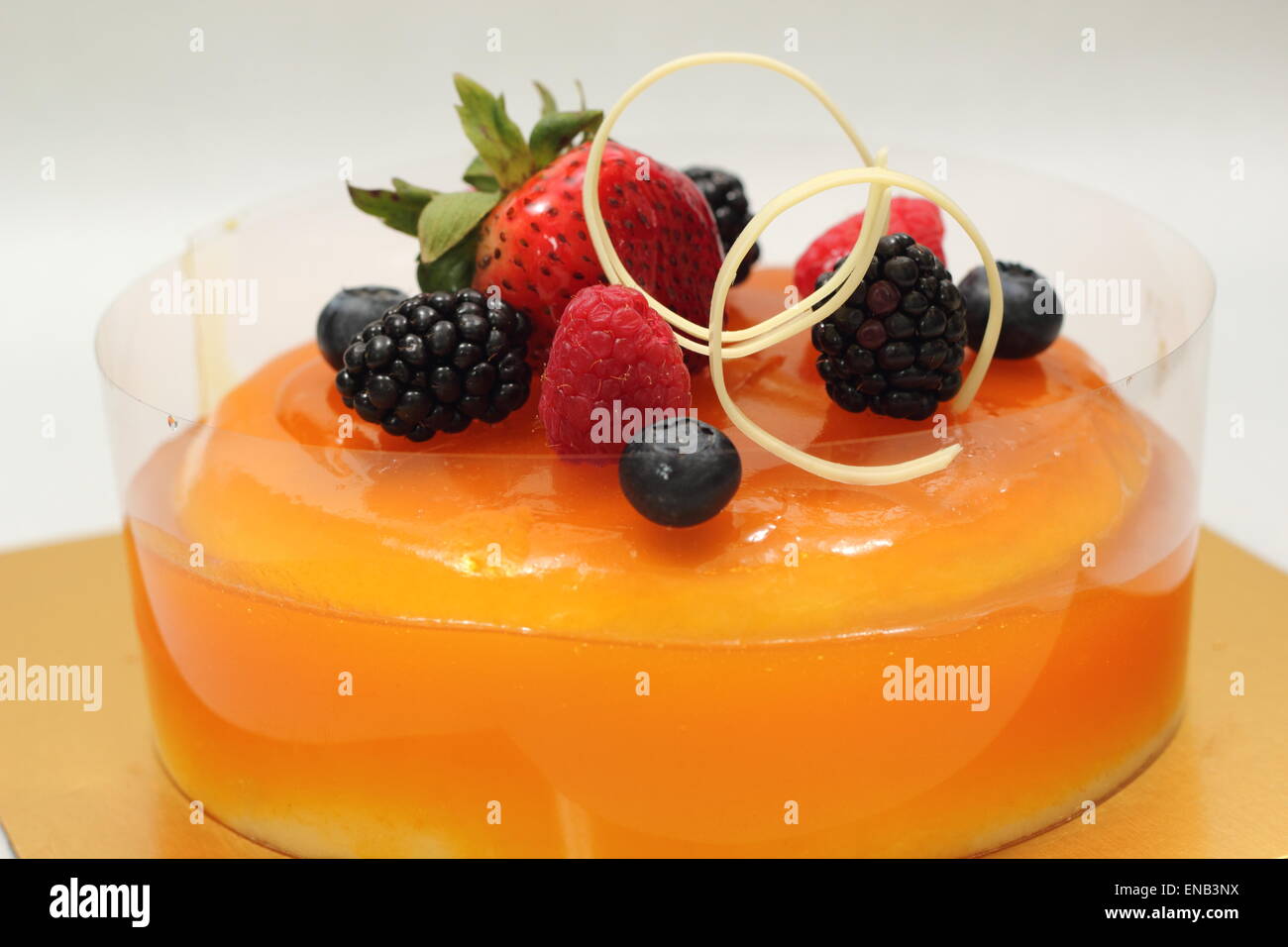 Orange jelly cake and mixed berry garnished Stock Photo Alamy