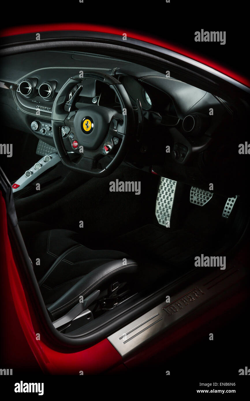 Ferrari F12 in red interior shot of dash, steering wheel, pedals and  controls on a black background Stock Photo - Alamy