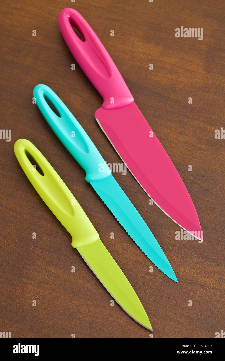 Set of large and small serrated kitchen knives color on a wooden board