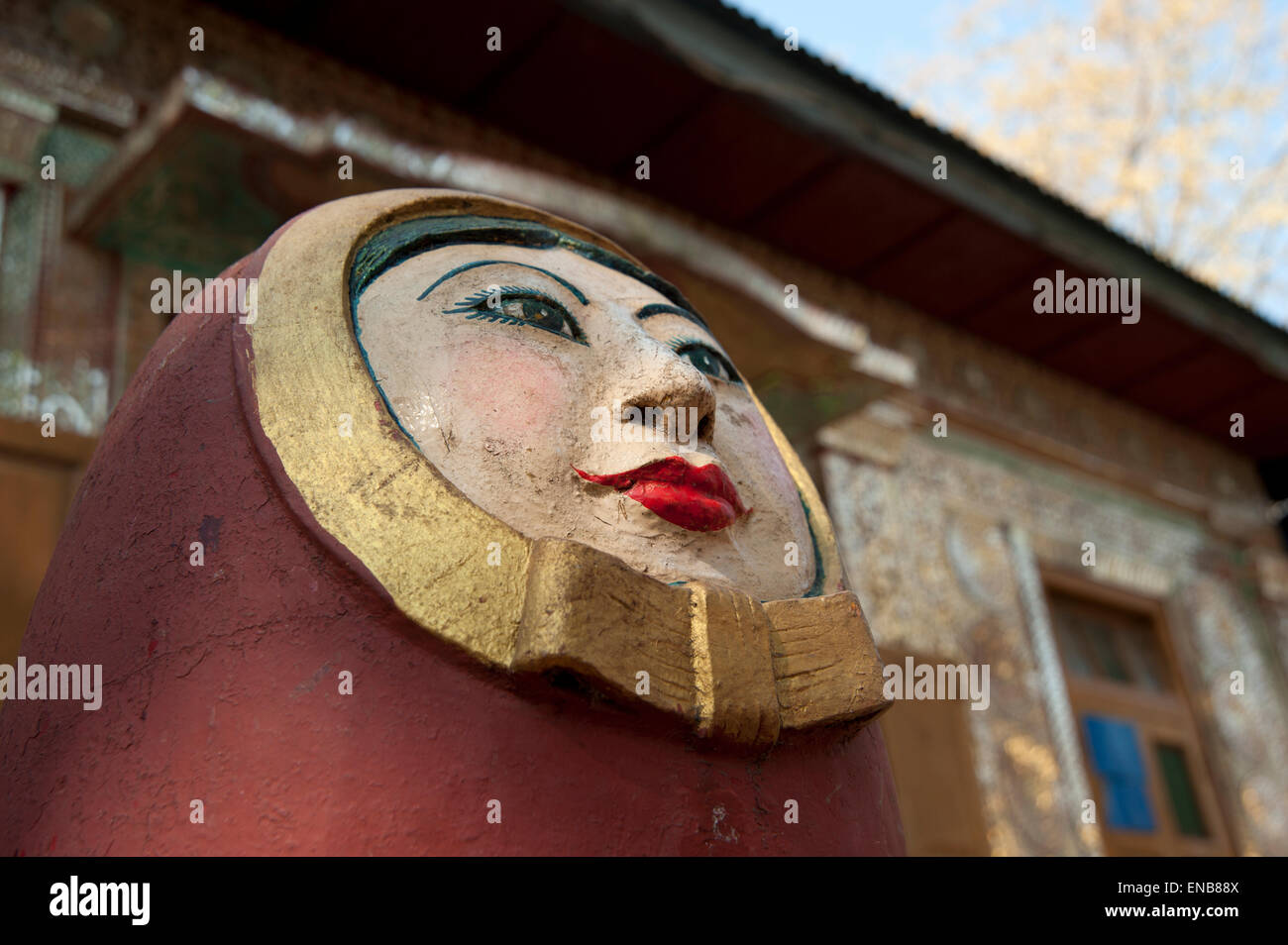 Close up detail of an red painted egg shaped stone statue of a spirit or Nat at the entrance to Mount Popa Myanmar Stock Photo