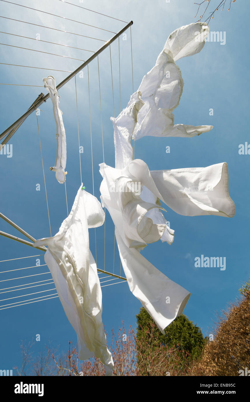 white washing blowing on rotary line on hot breezy day - low angle view Stock Photo