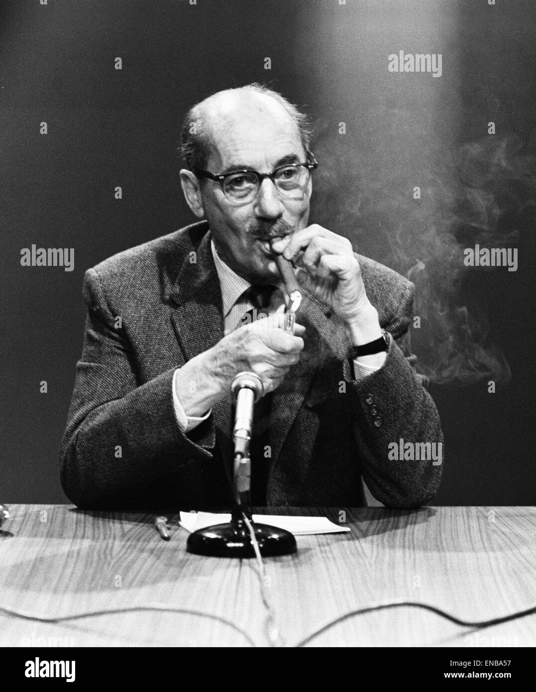 American comedy actor Groucho Marx smoking a cigar at a press conference in London, before he makes his first exclusive British television appearance in a new quiz show titled 'The Celebrity Game'. 1st June 1964. Stock Photo
