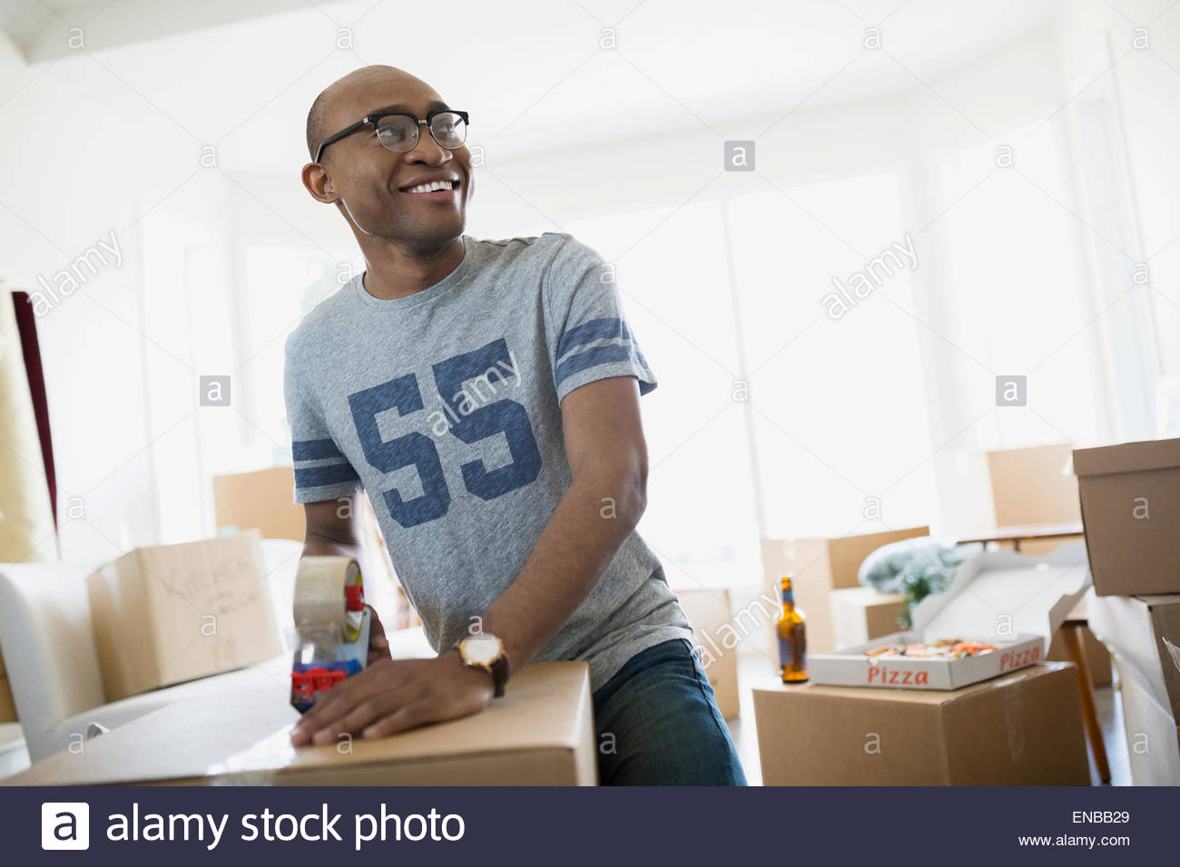 Smiling man taping moving box Stock Photo