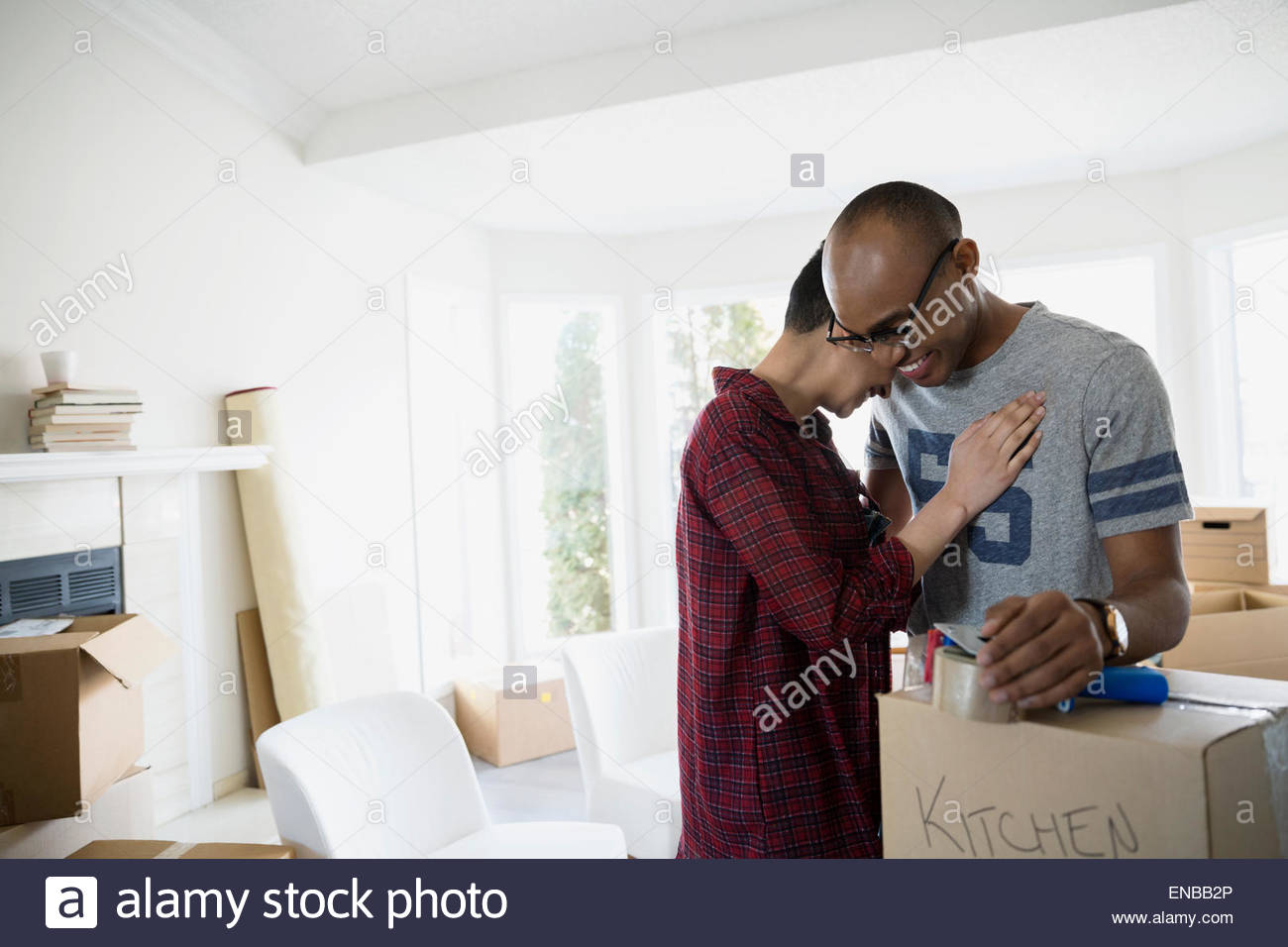 Affectionate couple with moving boxes hugging Stock Photo