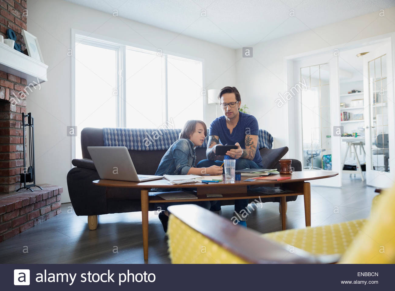 Father helping son with homework in living room Stock Photo - Alamy