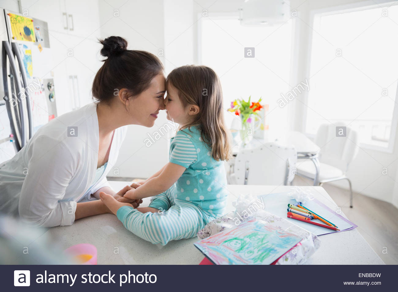 Affectionate mother and daughter rubbing noses in pajamas Stock Photo