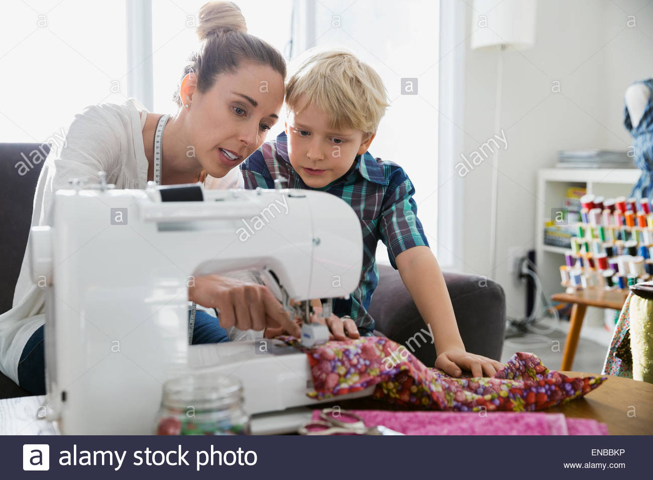Mother teaching son to sew at sewing machine Stock Photo Alamy