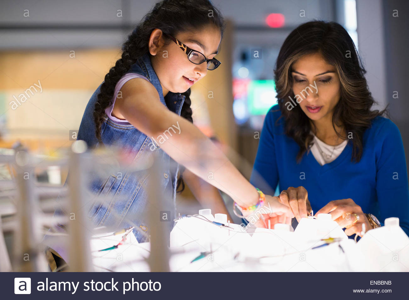 Mother daughter playing electricity exhibit at science center Stock Photo