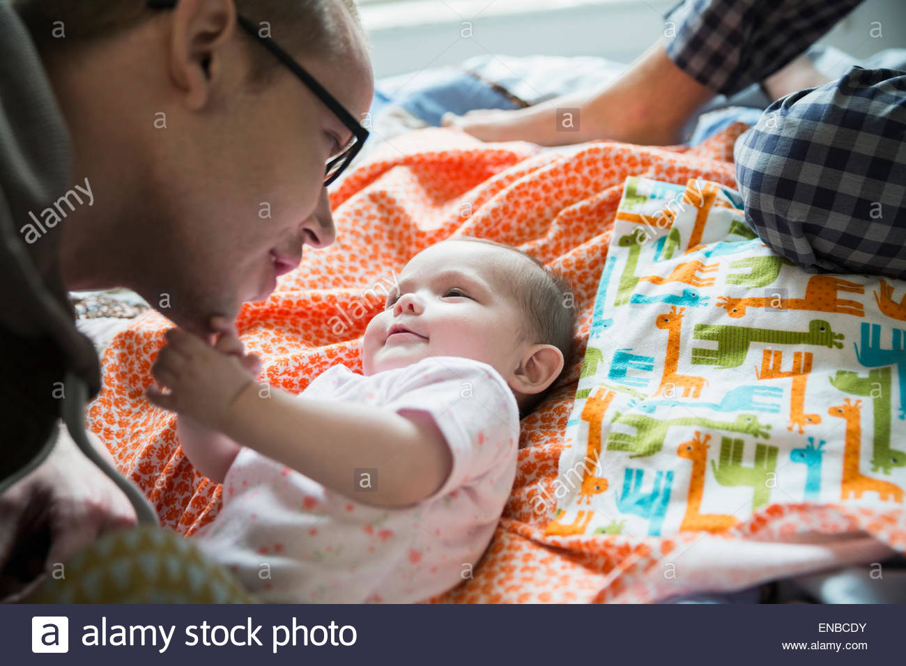 Father playing with baby daughter on bed Stock Photo