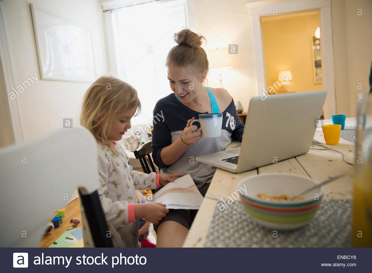Daughter showing mother at laptop drawing Stock Photo