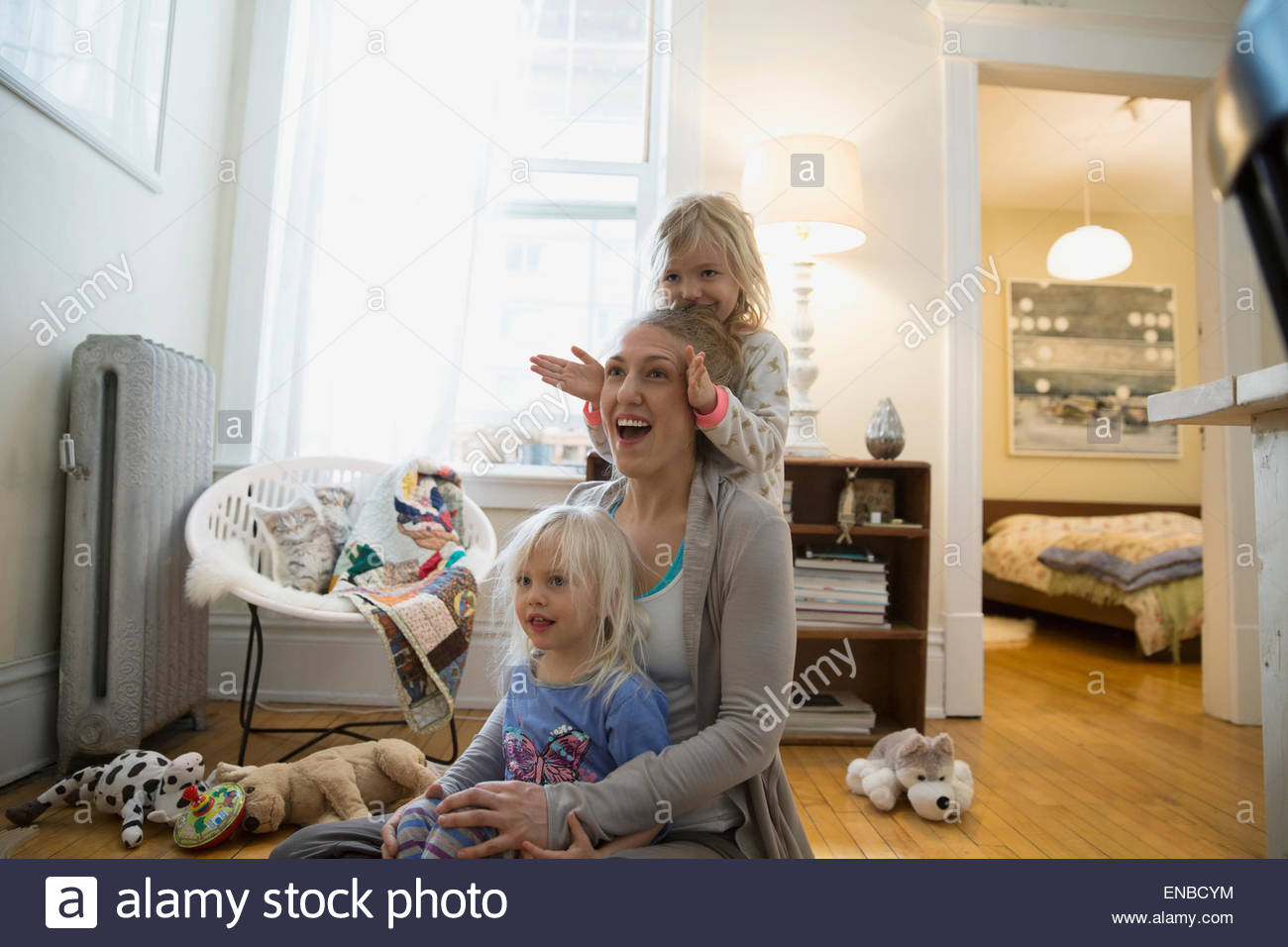 Mother and daughters on living room floor Stock Photo