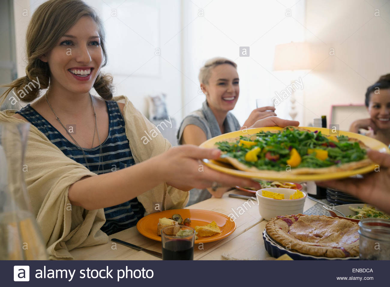 Woman passing food at dinner party Stock Photo Alamy