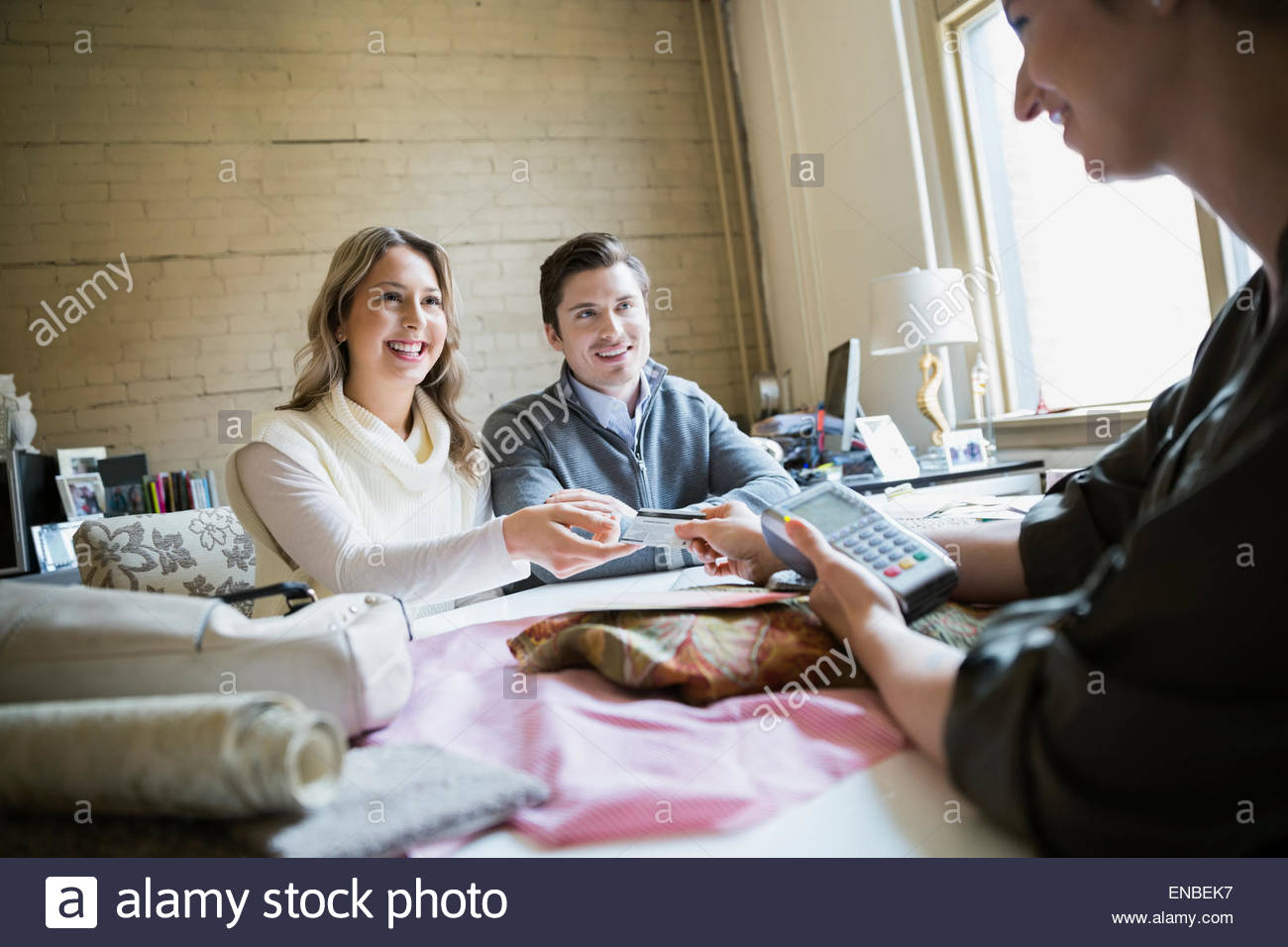 Couple paying interior designer with credit card Stock Photo Alamy