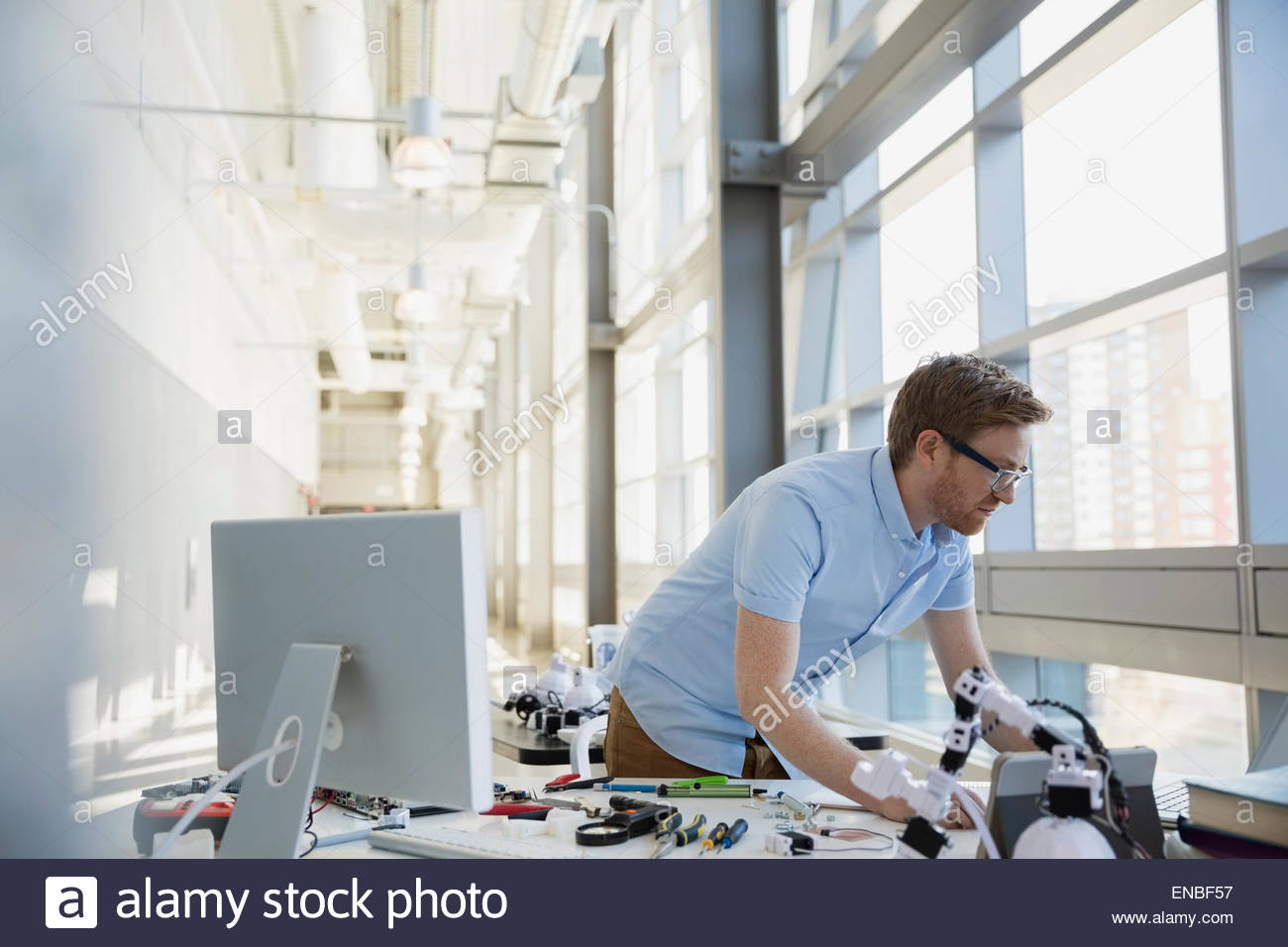 Engineer working at desk with robotics Stock Photo Alamy