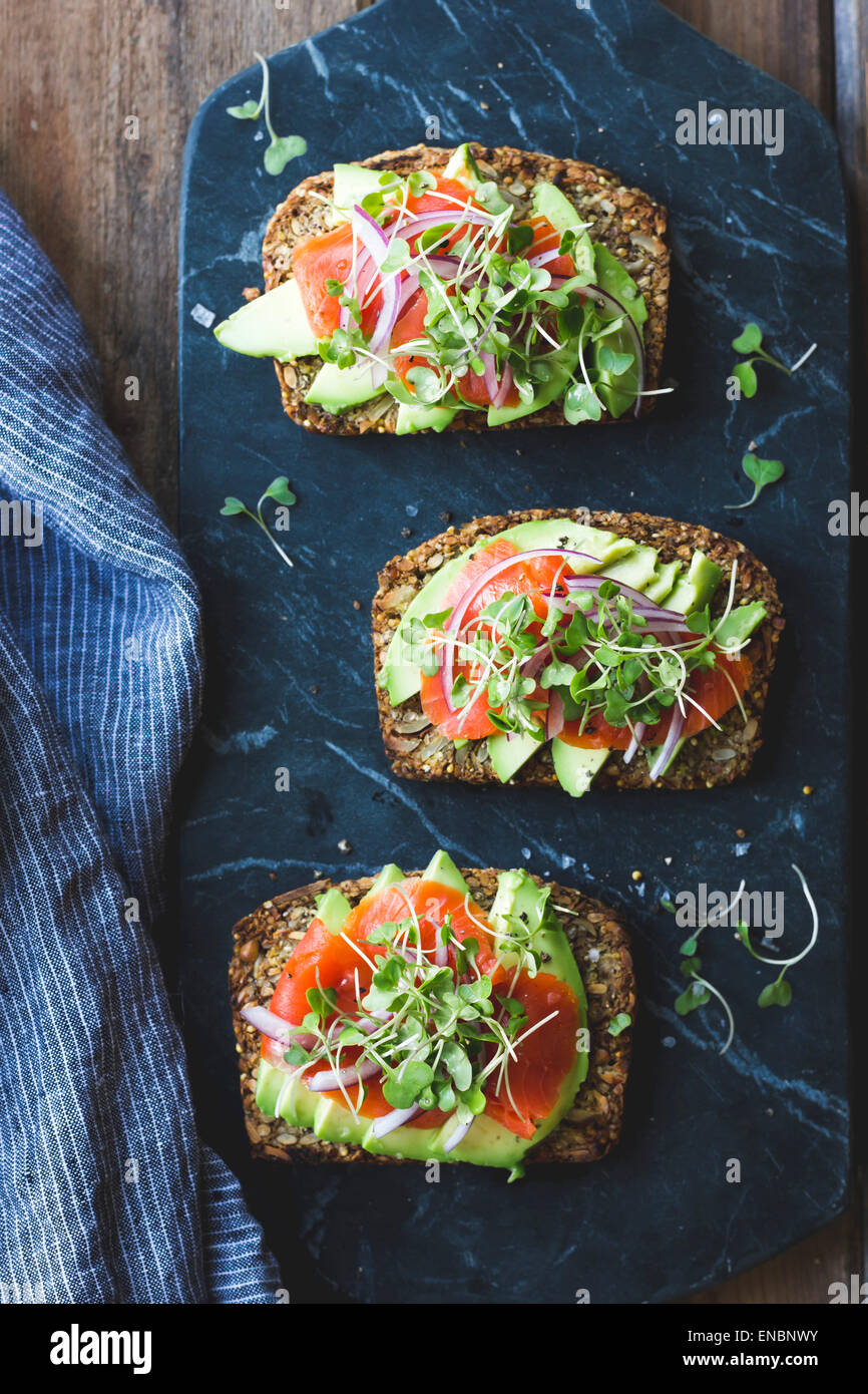 A Gluten-Free Vegan Nut and Seed Bread with avocado salad topping Stock Photo