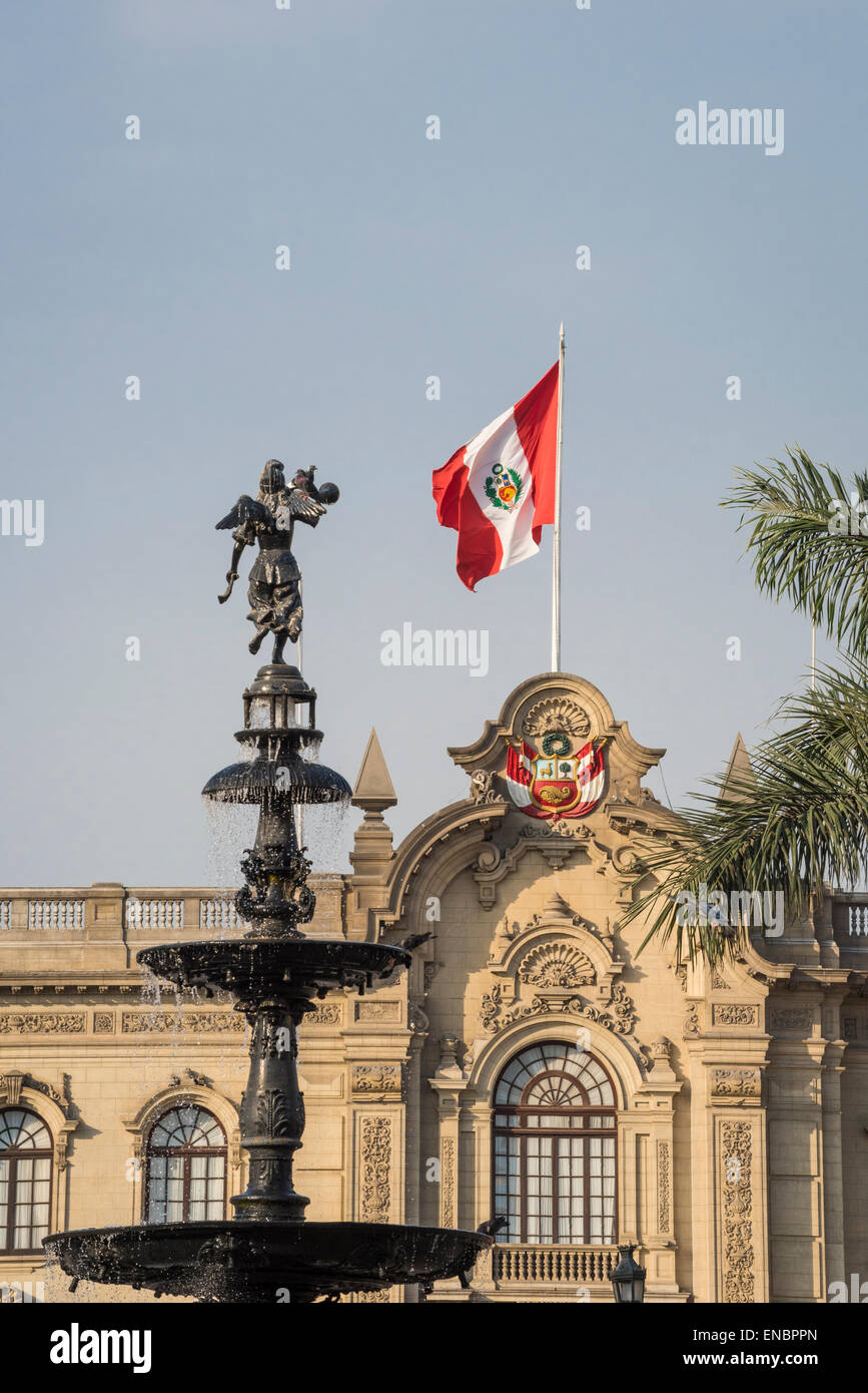 Flag of Peru on Palacio Gobierno (Government Palace) and bronze water fountain in Plaza Mayor; Lima, Peru. Stock Photo
