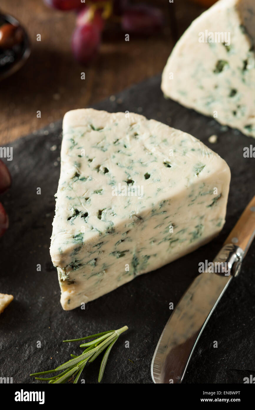 Organic Blue Cheese Wedge with Olives and Grapes Stock Photo