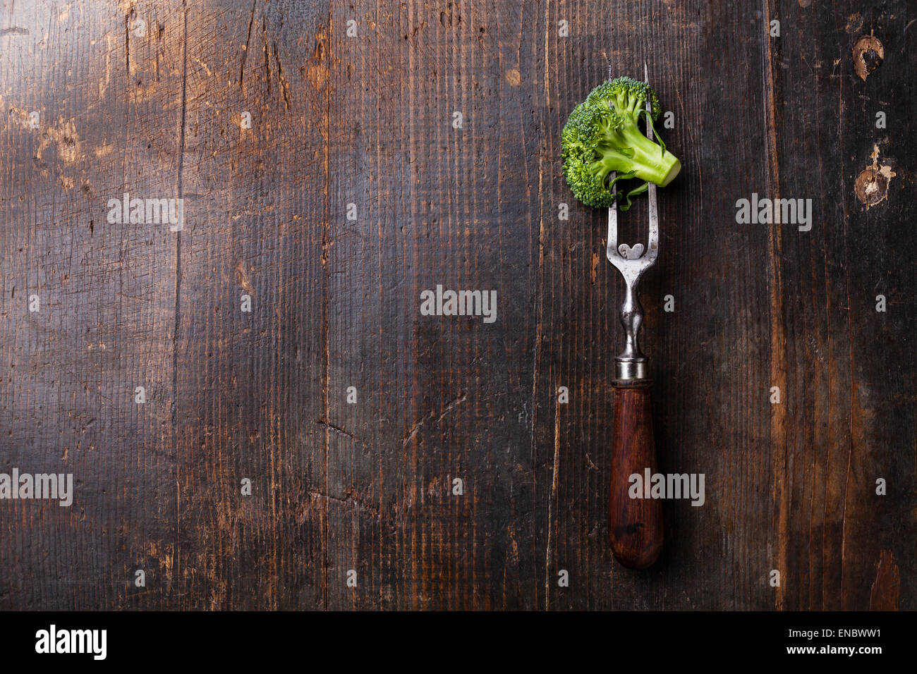 Fresh broccoli on meat fork on dark wooden background Stock Photo