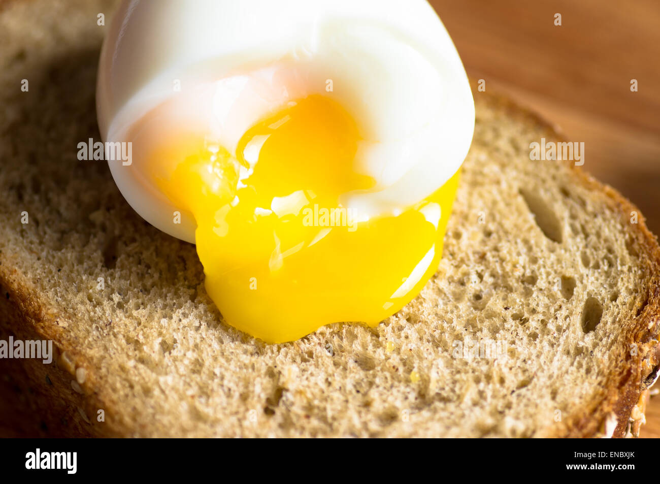 The yolk flows from boiled egg on toast Stock Photo Alamy