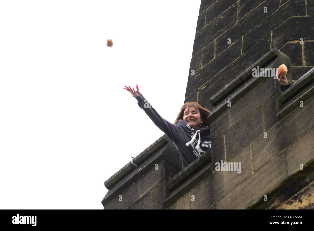 Rotherham, UK. 2nd May 2015. A church member throws a piece of bread from the church tower at Wath All Saints Parish Church near Rotherham, South Yorkshire. One hundred bread bun are thrown to the waiting crowds below as part of the annual Wath Festival. Picture: Scott Bairstow/ Alamy Stock Photo