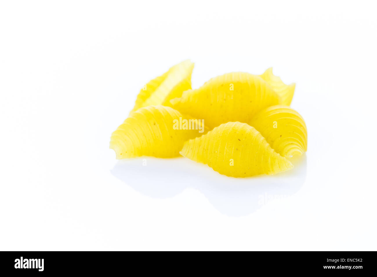 Organic yellow shell pasta on a white background Stock Photo - Alamy