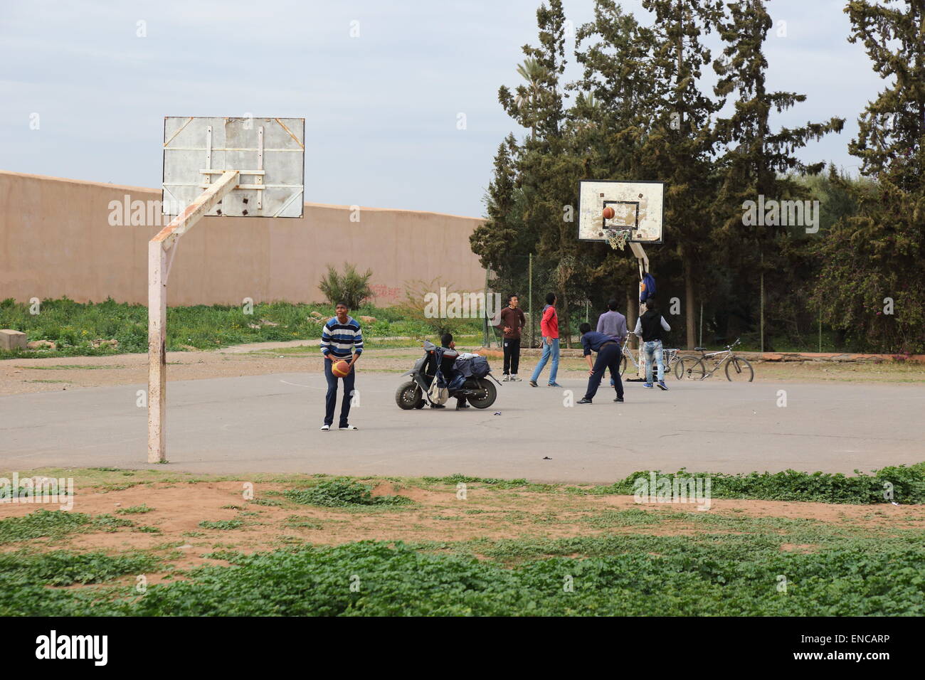 Young men playing basketball outdoors close to the walls of The Agdal