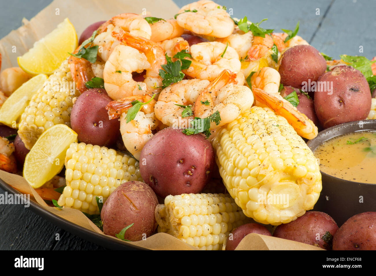 shrimp boil with corn, red potatoes and lemon Stock Photo - Alamy
