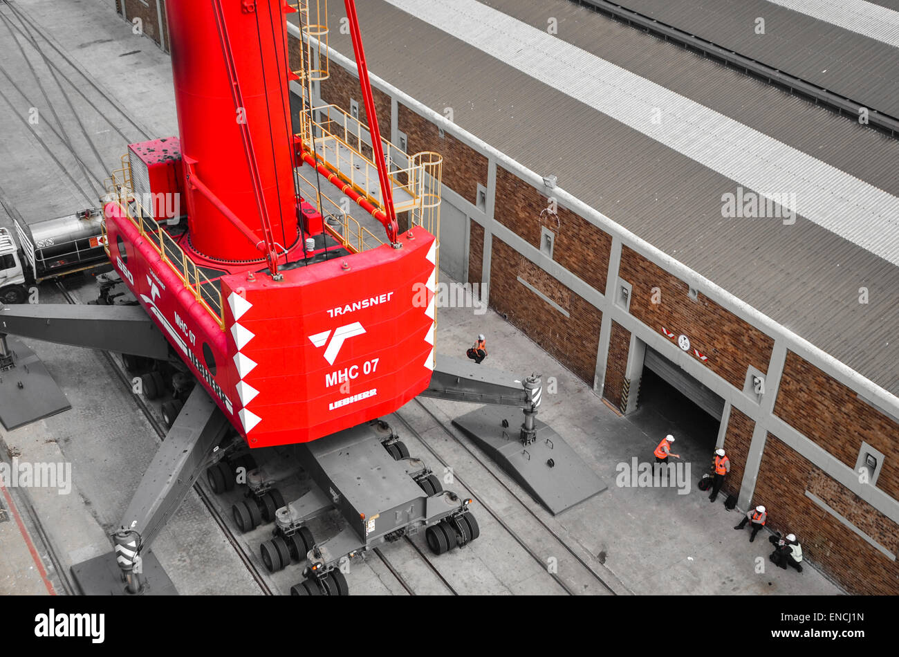 Workers below a Liebherr crane in the port of Cape Town, South Africa Stock Photo