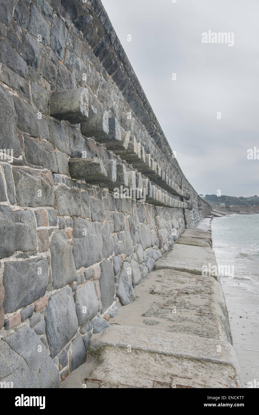 Granite sea wall on the west coast of Guernsey, Channel Islands. Stock Photo