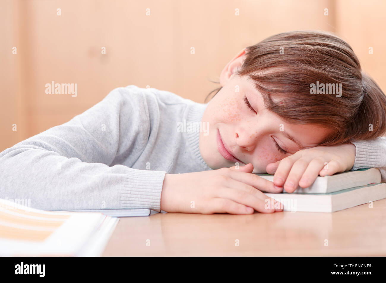 Little boy sleeping on desk Stock Photo