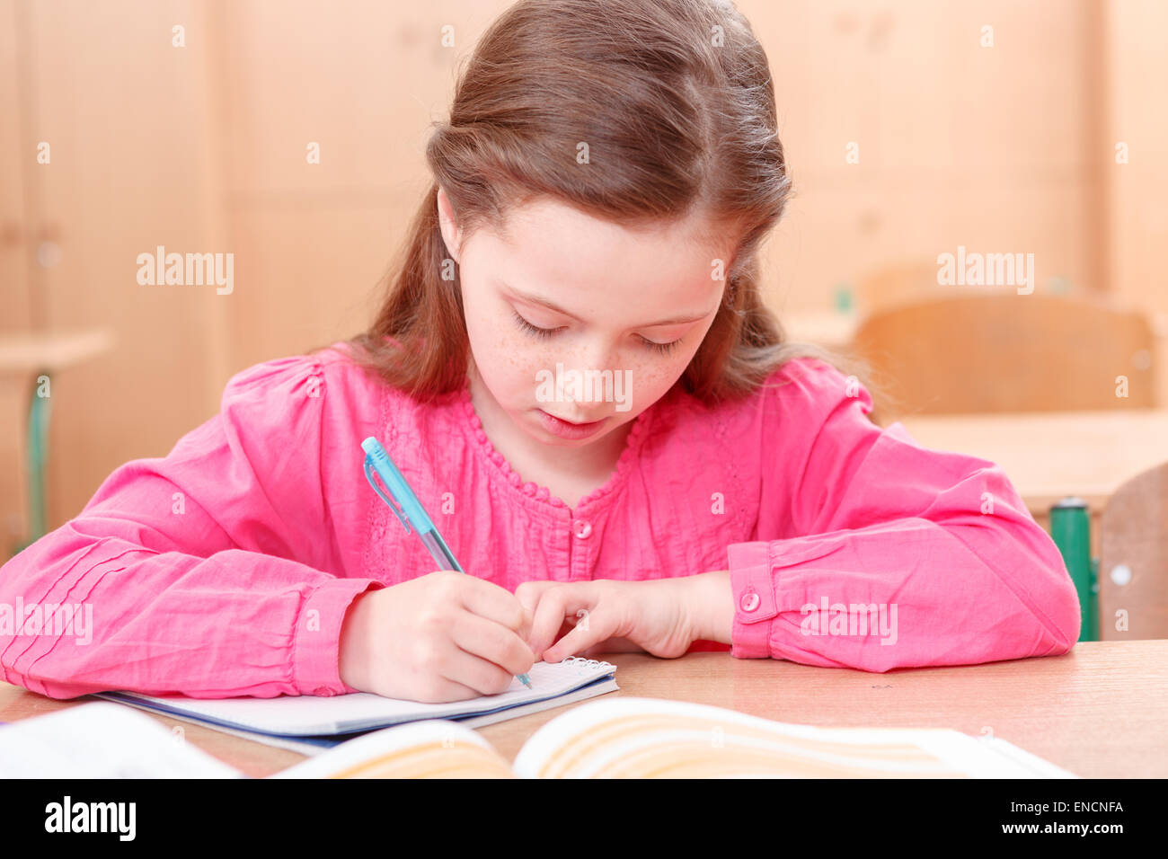 Little writing girl during classes Stock Photo - Alamy