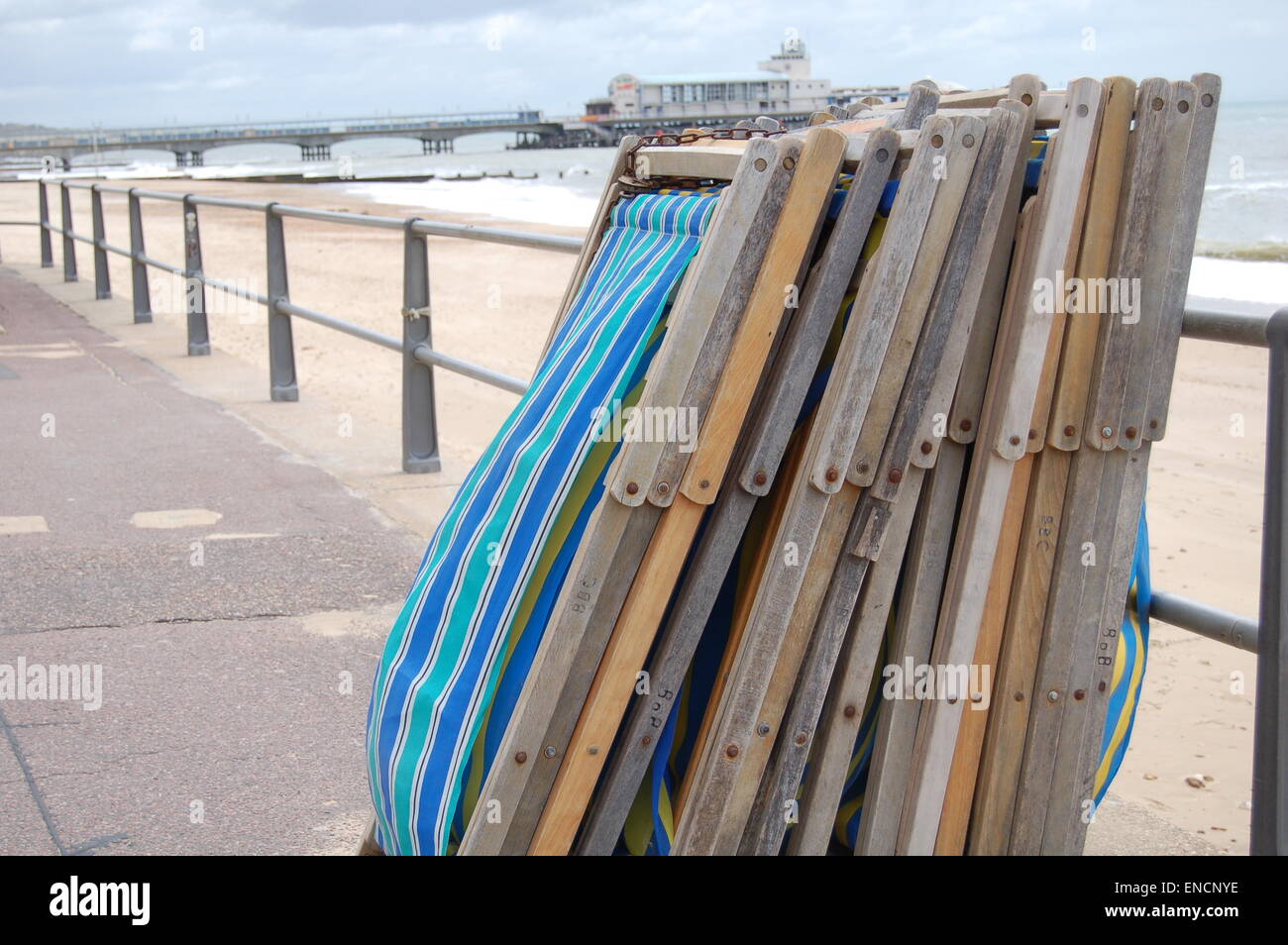 A stack of deck chairs resting up against some railings. Bournemouth