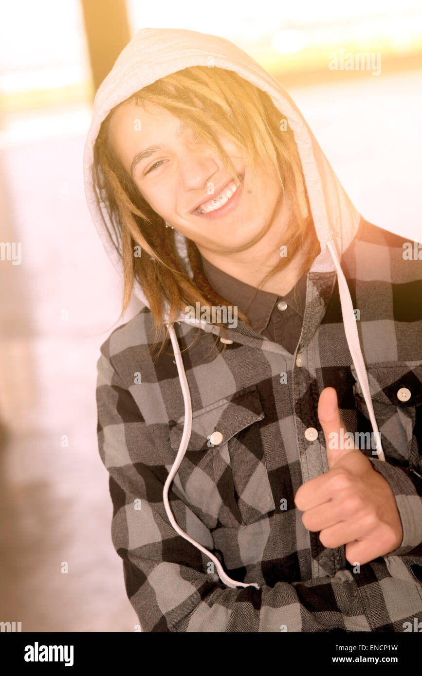 Lifestyle portrait of a young man with rasta hairs warm tones filter applied Stock Photo