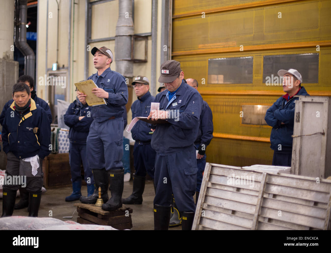 Auctioneer starts the bidding at the daily tuna auction whilst staff look on, Tsukiji Market, Tokyo, Japan. Stock Photo