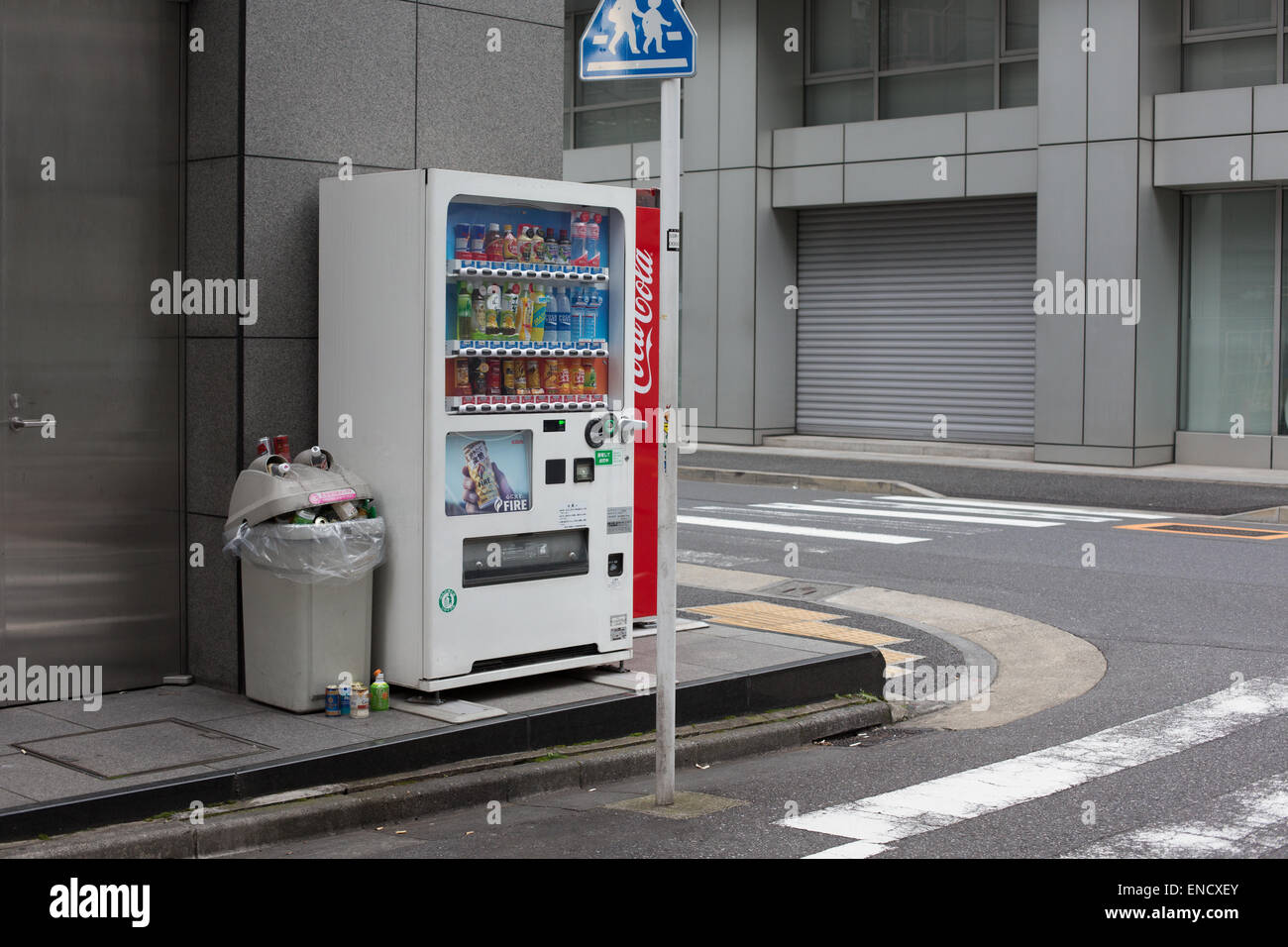 An over-flowing rubbish bin next to a drinks vending machine, Tokyo, Japan. Stock Photo