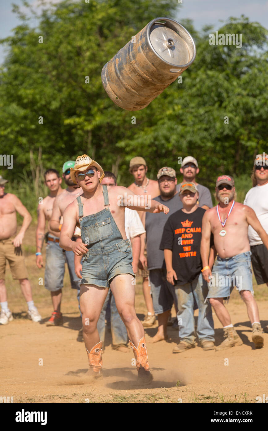 A competitor tosses a beer barrel during the 2015 National Red Neck Championships May 2, 2015 in Augusta, Georgia. Hundreds of people joined in a day of country sport and activities. Stock Photo