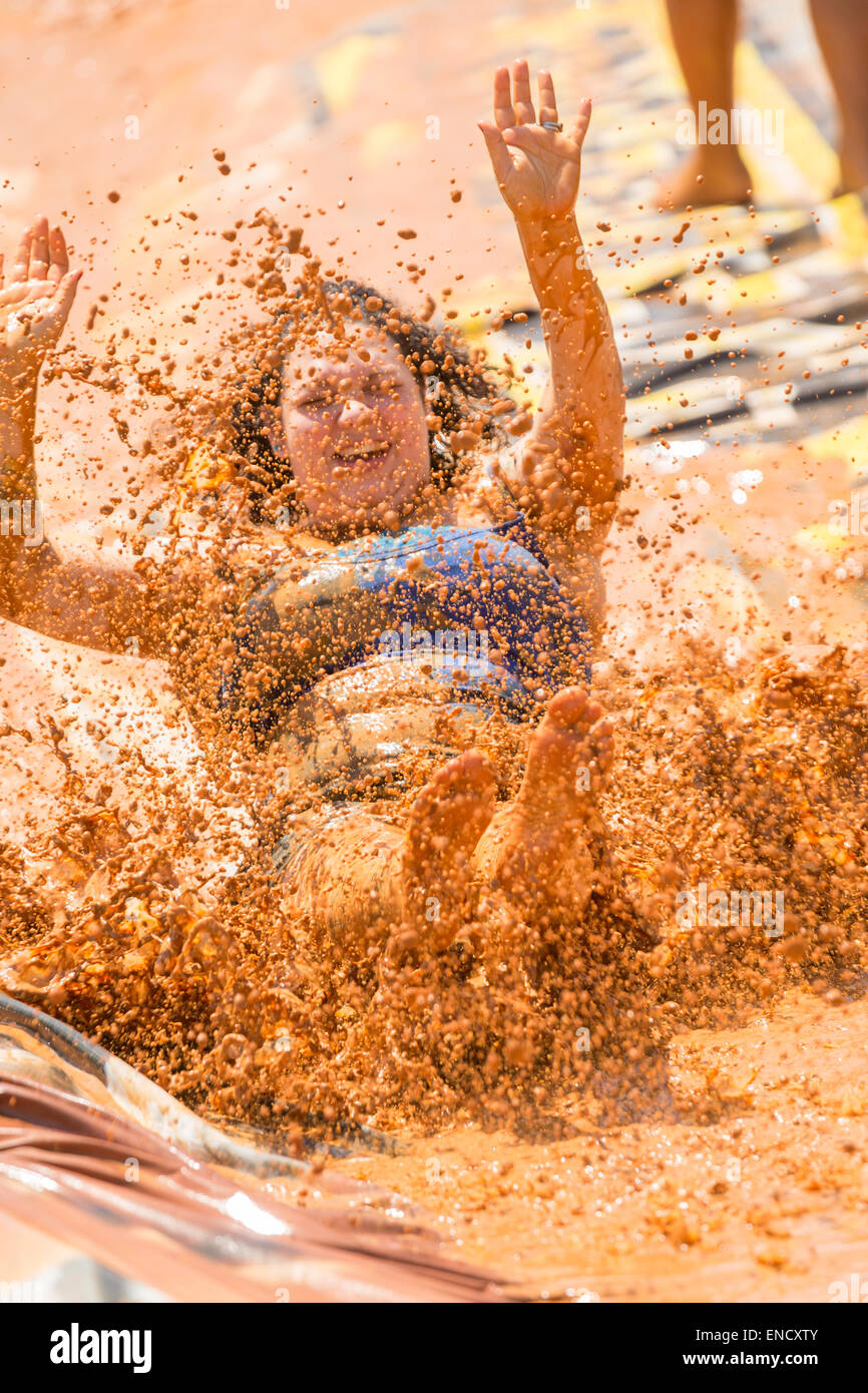 Augusta, Georgia, USA. 2nd May, 2015. A young girl slips down a mud slide during the 2015 National Red Neck Championships May 2, 2015 in Augusta, Georgia. Hundreds of people joined in a day of country sport and activities. Stock Photo