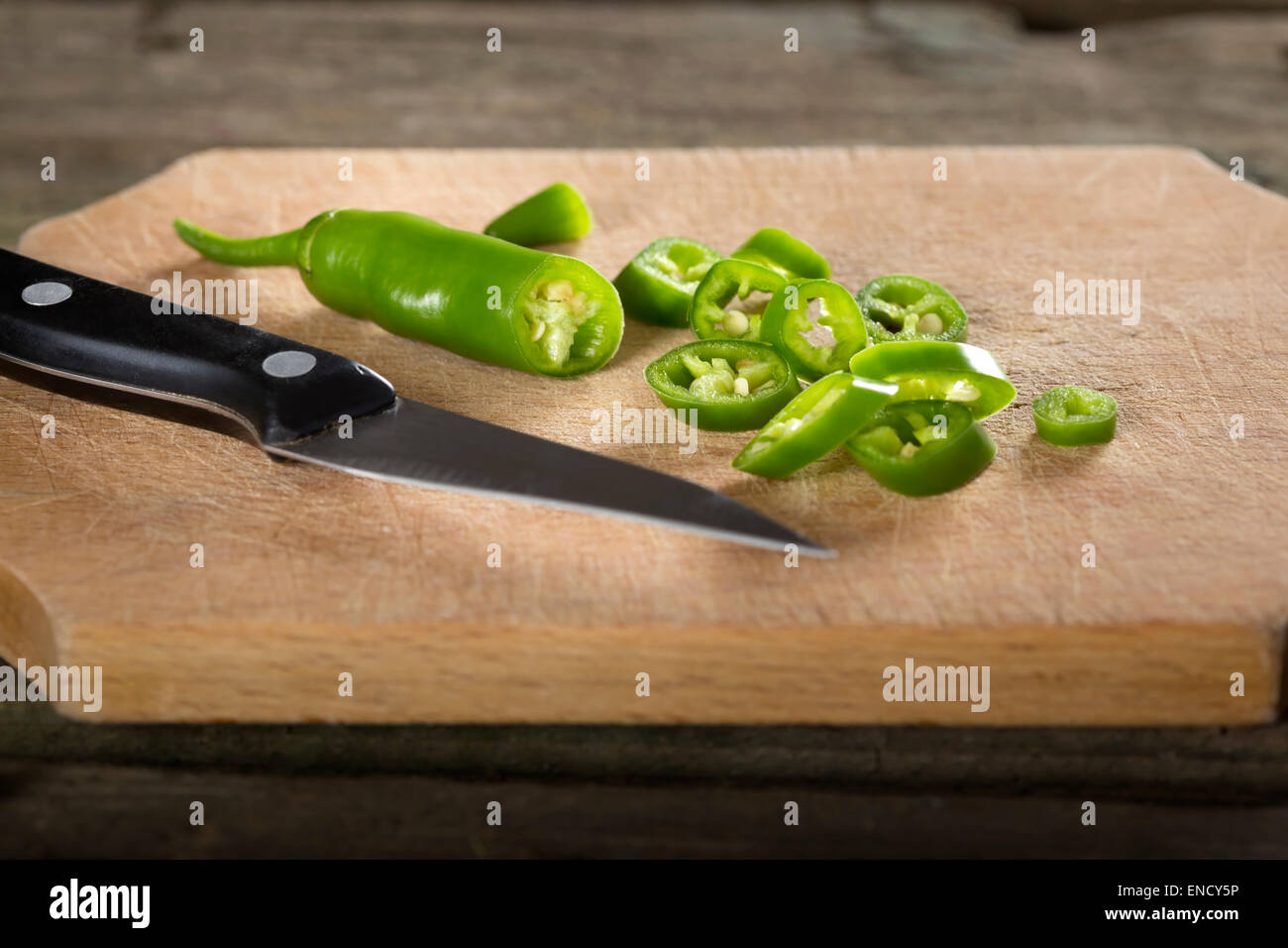 Chopped Fresh green chilli peppers On A cutting Wooden Board Stock