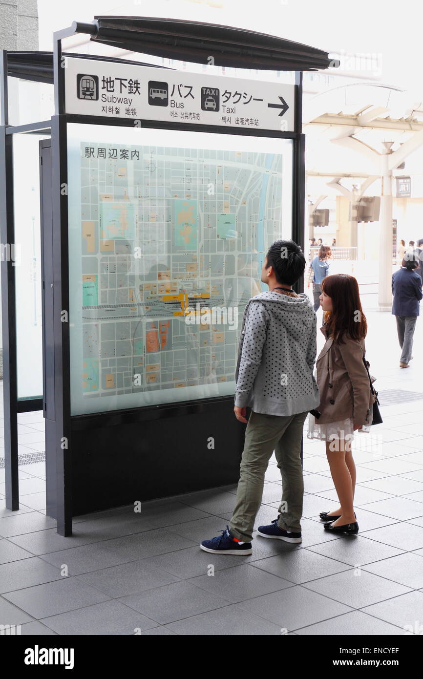 Young Asian Couple Lo Ng At The Bus Information Schedule Board Kyoto Train Station Japan Young Asian Couple Lo Ng At The Bus Information Schedule Board Kyoto Train Station Japan